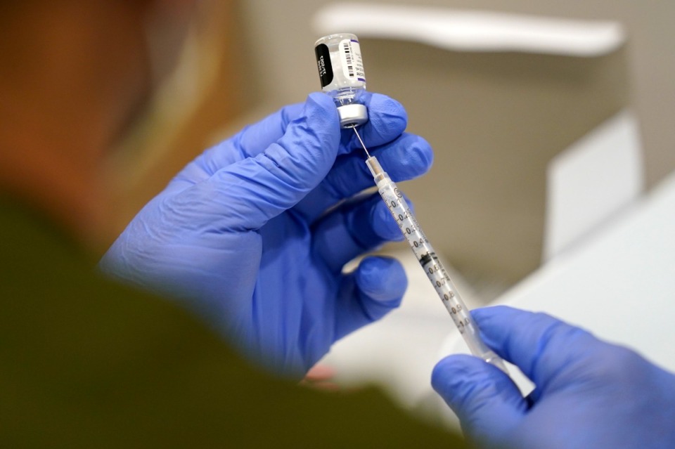 <strong>A healthcare worker fills a syringe with the Pfizer COVID-19 vaccine at Jackson Memorial Hospital on Oct. 5, 2021, in Miami. The U.S. is expanding COVID-19 boosters as it confronts the Omicron surge, with the Food and Drug Administration allowing extra Pfizer shots for children as young as 12</strong>. (AP Photo/Lynne Sladky, File)