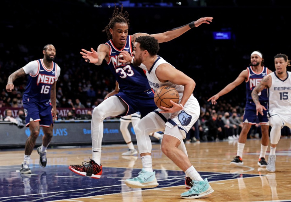 <strong>Grizzlies guard Tyus Jones, center right, drives to the basket past Brooklyn Nets forward Nic Claxton (33) on Jan. 3, 2022, in New York.</strong> (Adam Hunger/AP)