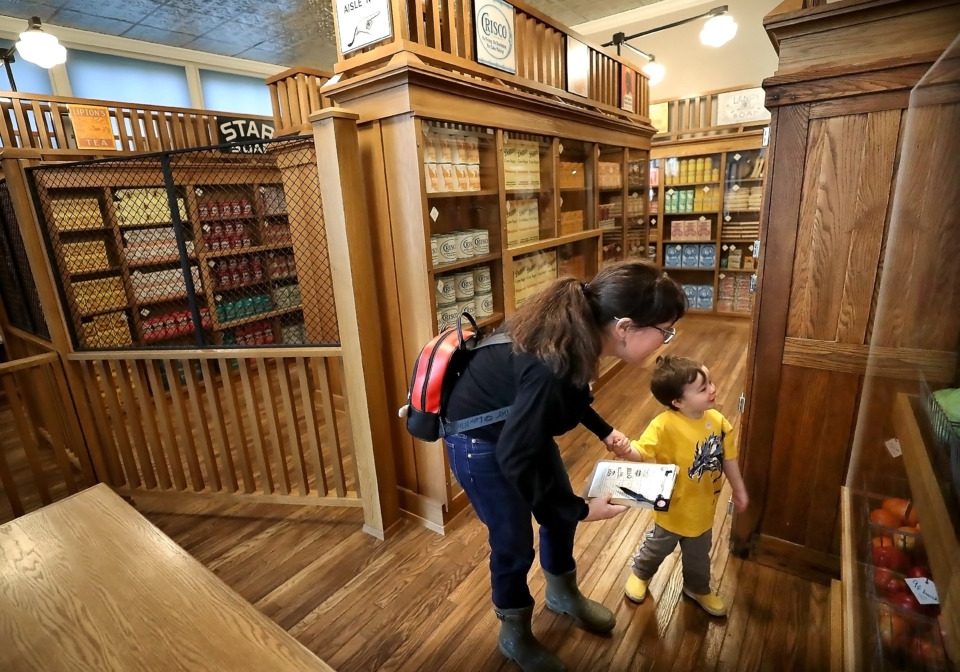 <strong>Liz Marlow and her son Ryan Malow, 3, hunt through the Piggly Wiggly exhibit at the Pink Palace Museum, looking for a checklist of dry goods on Feb. 28, 2019. Founded in Memphis by Clarence Saunders in 1916, Piggly Wiggly was the first self-service grocery store with shopping carts, individual pricing and check-out counters.</strong> (Jim Weber/Daily Memphian)