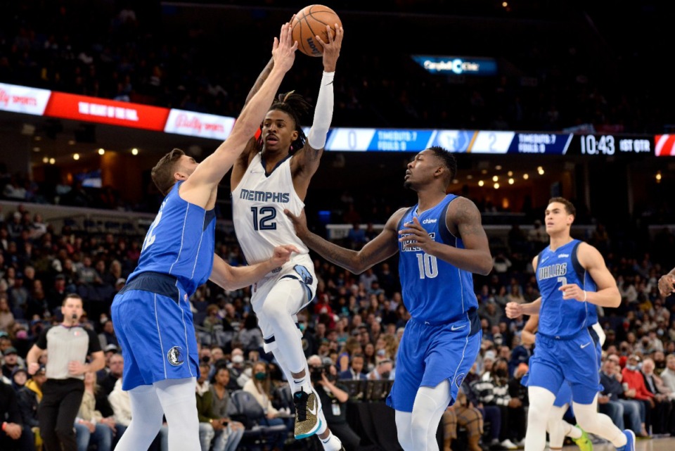 <strong>Grizzlies guard Ja Morant (12) goes up against Dallas Mavericks guard Luka Doncic and forward Dorian Finney-Smith (10) on Jan. 14, the night the win streak ended.</strong> (Brandon Dill/AP)