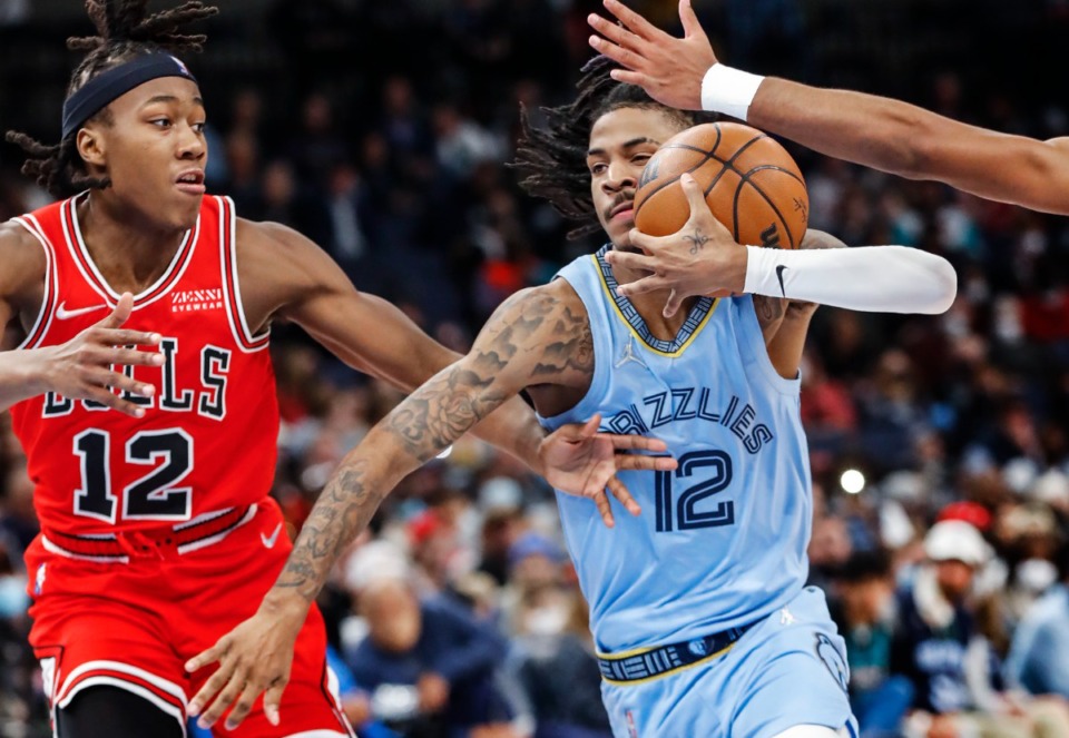 <strong>Memphis Grizzlies guard Ja Morant (right) grabs a loose ball while driving the lane against the Chicago Bulls defender Ayo Dosunmu (left) during action on Monday, Jan. 17, 2022.</strong> (Mark Weber/The Daily Memphian)