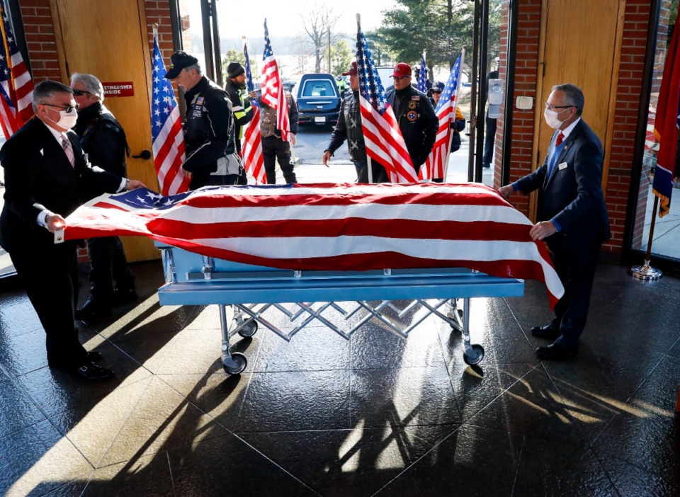 <strong>Funeral officiants place the casket of Navy Veteran James Allen Isaacs for a service on Tuesday, Jan. 18, 2022 at the West Tennessee Veterans Cemetery. Isaacs, who died in June, leaving behind no family to attend, was buried with community members in attendance.</strong> (Mark Weber/The Daily Memphian)