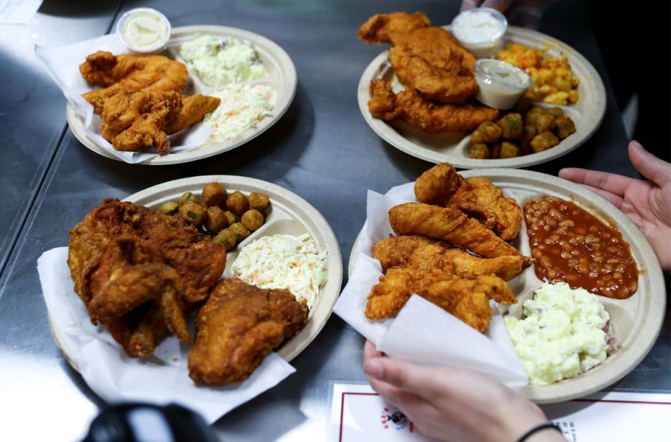 <strong>Servers carry out plates of food at Gus's World Famous Fried Chicken's new location in Germantown Jan. 22, 2022.</strong> (Patrick Lantrip/Daily Memphian)