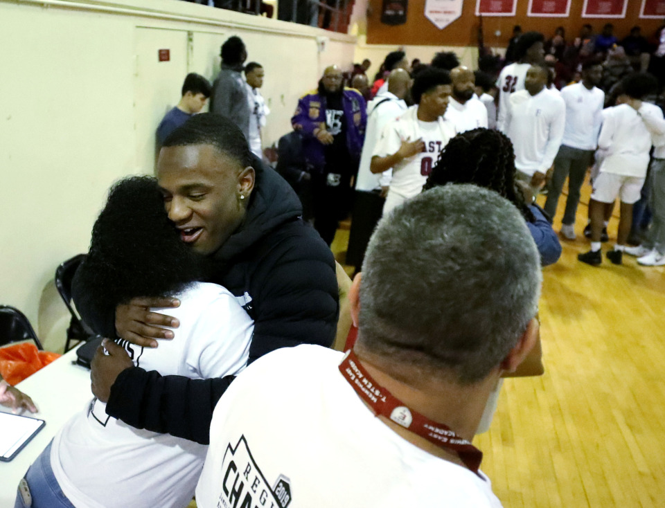 <strong>University of Memphis freshman guard Alex Lomax (center) hugs a friend inside the East High School gym after his jersey was retired Monday, March 4, 2019. The former East standout was honored during halftime of the game between East High and Bolton.</strong> (Houston Cofield/Daily Memphian)