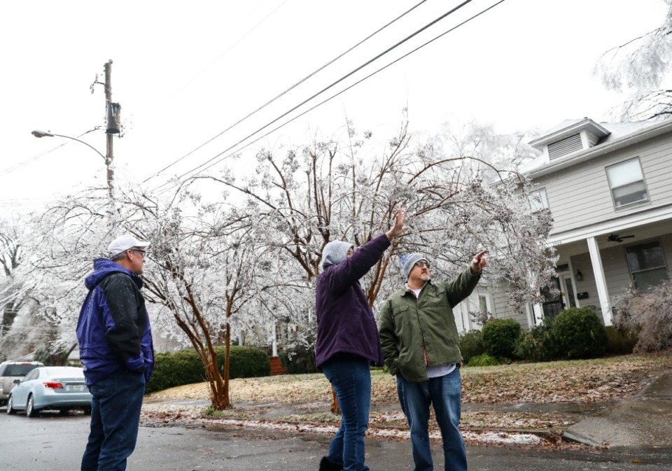 <strong>Russell Palmer (right) talks with Higbee Avenue neighbors about falling ice-covered tree branches.</strong> (Mark Weber/The Daily Memphian)