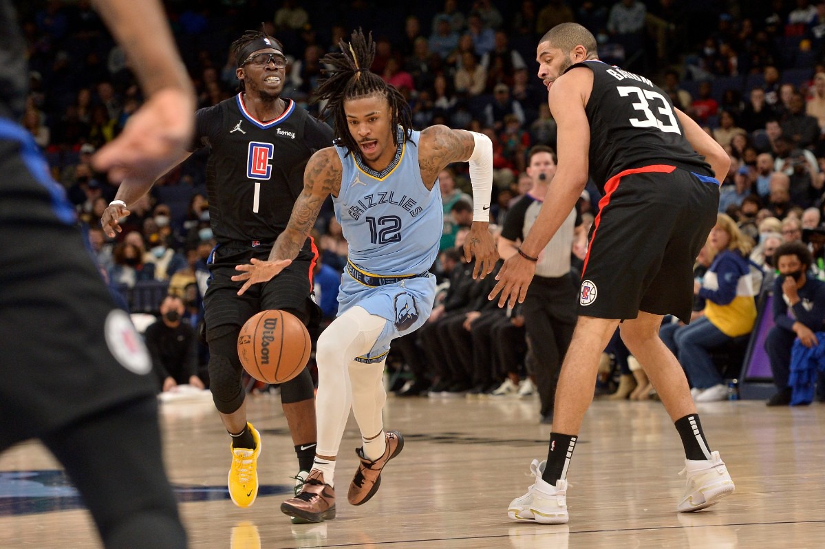 <strong>Memphis Grizzlies guard Ja Morant (12) drives the lane between Los Angeles Clippers guard Reggie Jackson (1) and forward Robert Covington (33) on Feb. 8.</strong> (Brandon Dill/AP)