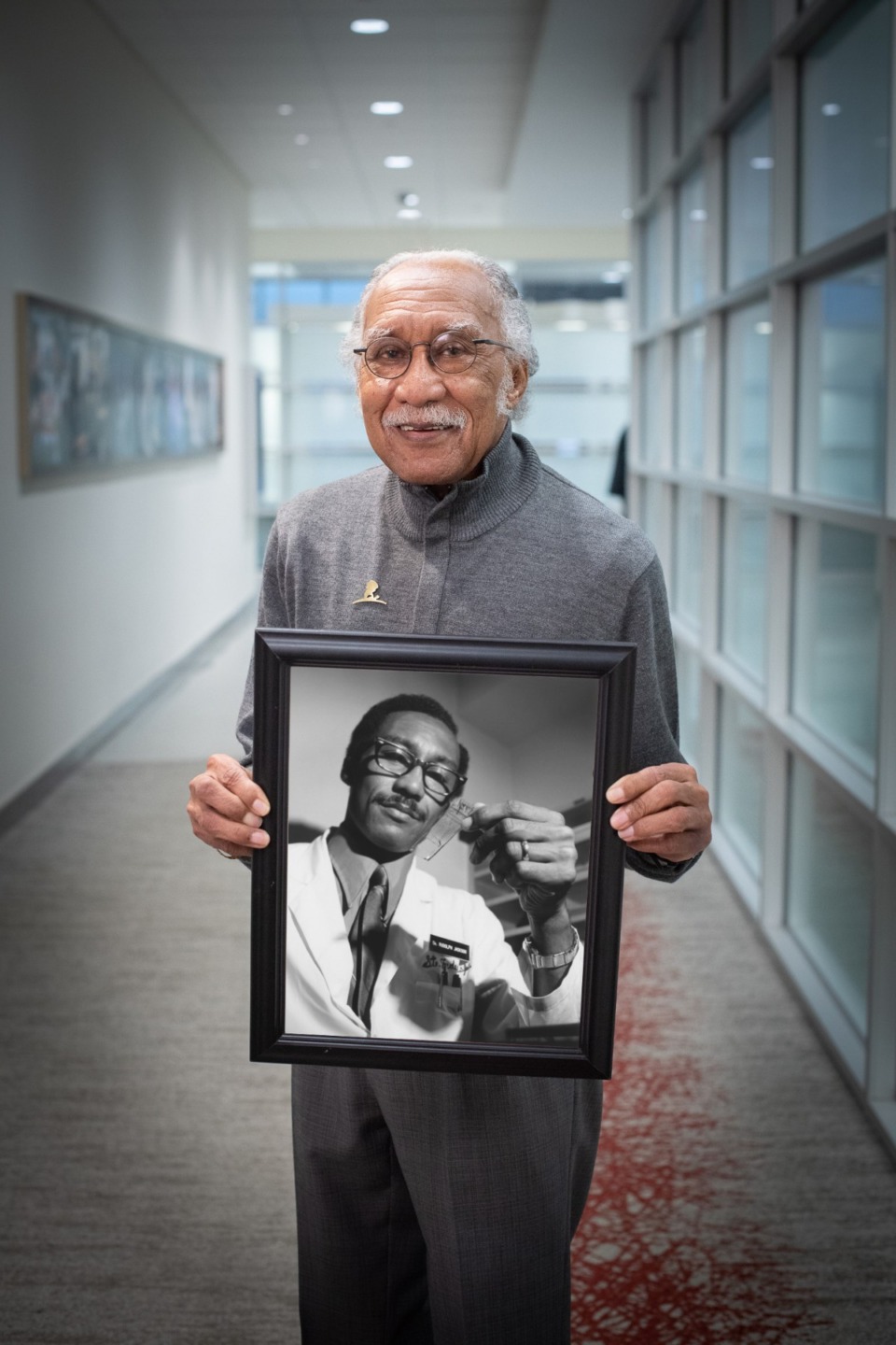 <strong>The late Dr. Rudolph Jackson, one of St. Jude&rsquo;s first black doctors, holds a photo of himself from 1968, the year he first joined the staff.</strong> (ALSAC/St. Jude Children&rsquo;s Research Hospital)