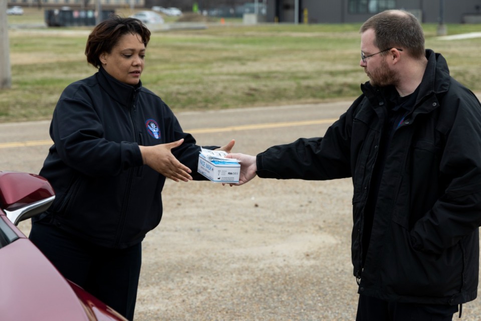 <strong>Ilea Hymes (left) and Dan Allen hand out face coverings during a Shelby County Government distribution of free surgical and N-95 masks at the Emergency Management Warehouse at 6393 Haley Road.</strong>&nbsp;(Brad Vest/Special to The Daily Memphian)