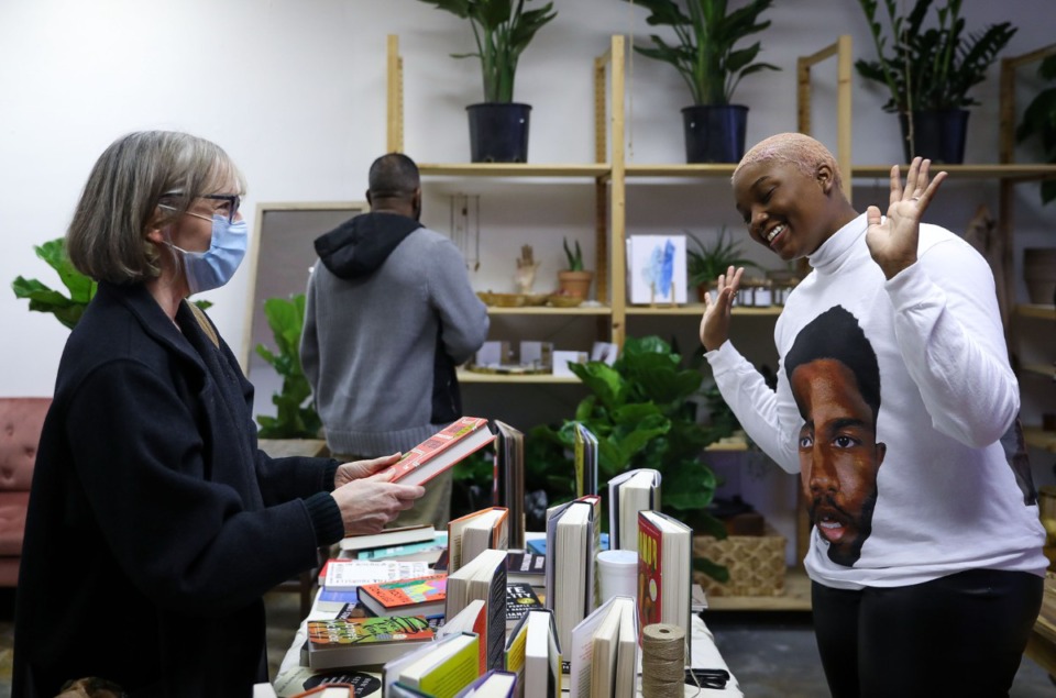 <strong>Jasmine Settles (right), owner of online bookstore Cafe Noir, chats with a customer during a pop-up sale at Terra Cotta Nursery on Summer Avenue Feb. 26, 2022.</strong> (Patrick Lantrip/Daily Memphian)