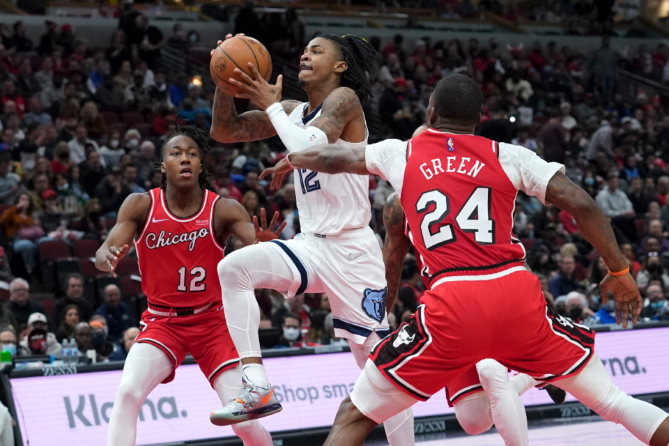 <strong>Memphis Grizzlies' Ja Morant, center, drives to the basket between Chicago Bulls' Ayo Dosunmu, left, and Javonte Green, right, during the second half of an NBA basketball game Saturday, Feb. 26, 2022, in Chicago.</strong> (AP Photo/Charles Rex Arbogast)