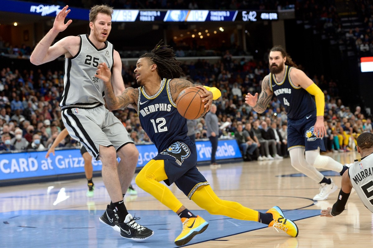 <strong>Memphis Grizzlies guard Ja Morant (12) drives between San Antonio Spurs center Jakob Poeltl (25) and guard Dejounte Murray (5) on Feb. 28, 2022, at FedExForum.</strong> (Brandon Dill/AP)