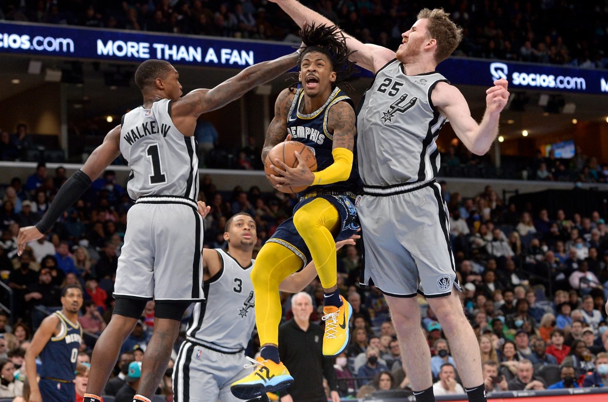 <strong>Memphis Grizzlies guard Ja Morant jumps to shoot between San Antonio Spurs guard Lonnie Walker IV (1) and center Jakob Poeltl (25) on Feb. 28, 2022, at FedExForum.</strong> (Brandon Dill/AP)