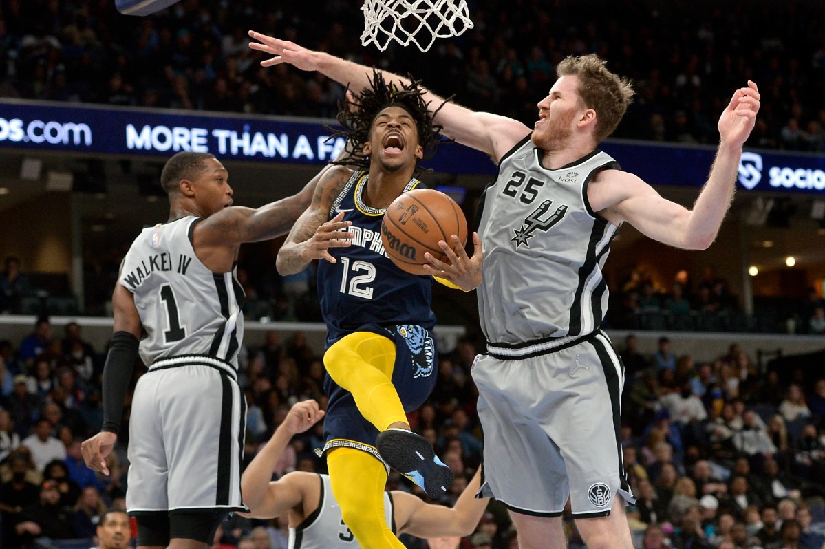 <strong>Memphis Grizzlies guard Ja Morant (12) jumps to shoot between San Antonio Spurs guard Lonnie Walker IV (1) and center Jakob Poeltl (25) on Feb. 28, 2022, at FedExForum.</strong> (Brandon Dill/AP)