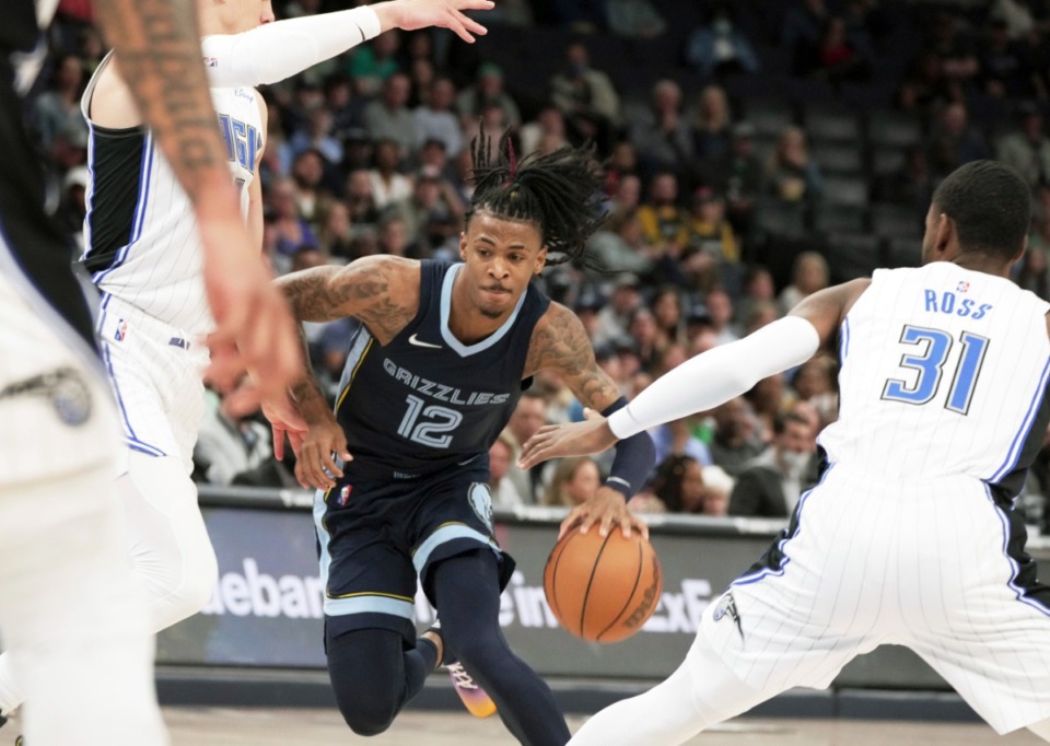 <strong>Memphis Grizzlies' Ja Morant (12) gets past the Orlando Magic defense in the first half of an NBA basketball game Saturday, March 5, 2022, at FedExForum.</strong> (AP Photo/Karen Pulfer Focht)