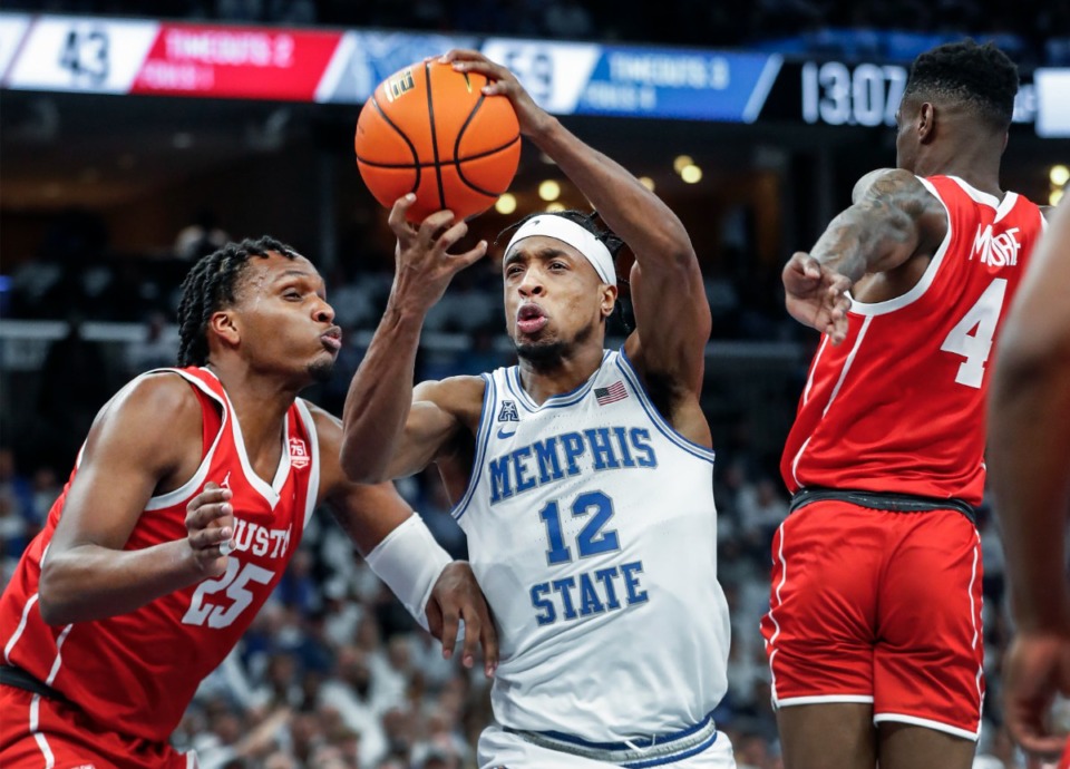 <strong>Memphis forward DeAndre Williams (middle) drives the lane against the Houston defense during game action on Sunday, March 6, 2022.</strong> (Mark Weber/The Daily Memphian)