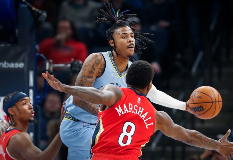<strong>Memphis Grizzlies guard Ja Morant (back) makes a pass around Pelican Naji Marshall (front) on Tuesday, March 8, 2022.</strong> (Mark Weber/The Daily Memphian)