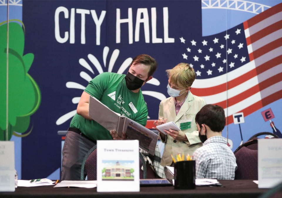 <strong>Volunteer Cliff Kelly helps Grahamwood Elementary students working in the City Hall section of JA BizTown on Tuesday, March 8.</strong> (Patrick Lantrip/Daily Memphian)