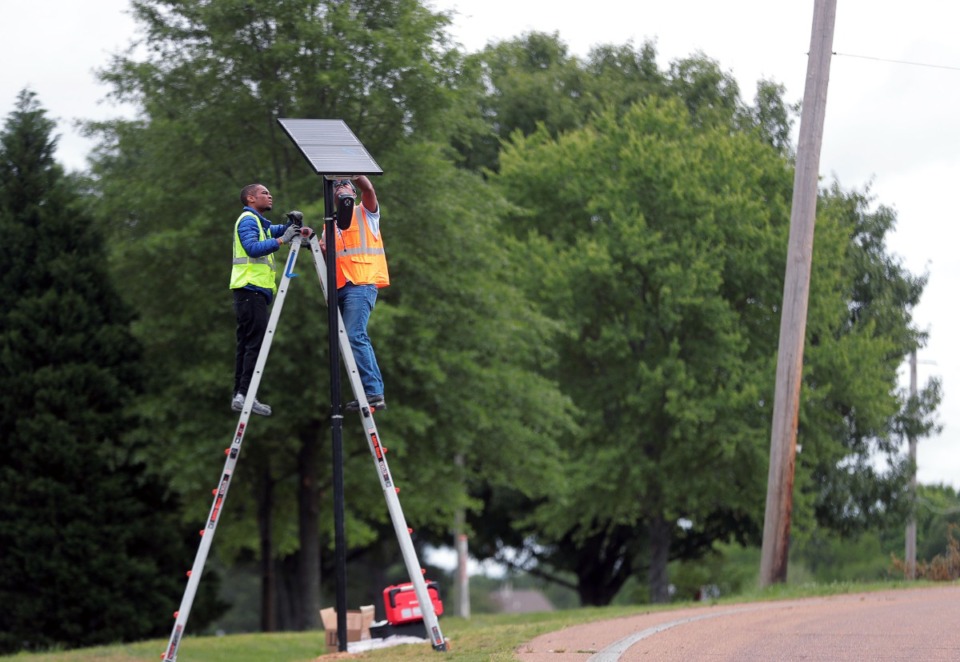 <strong>Christian Pratt (left) and Tommy Owens with Flock Safety install a security camera near the intersection of Highway 64 &amp; Davies Plantation Road on May 19, 2020.</strong> (Patrick Lantrip/Daily Memphian file)