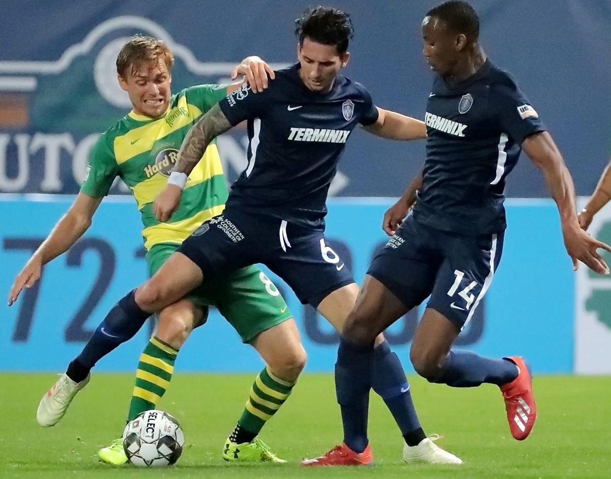 <strong>Dan Metzger (6) and Rashawn Dally (14) steal the ball from Tampa's Zach Steinberger (8) during the 901 FC season opener against the Tampa Rowdies at Autozone Park on March 9, 2019. The Rowdies beat Memphis 1-0 with a penalty kick early in the first half.</strong> (Jim Weber/Daily Memphian)
