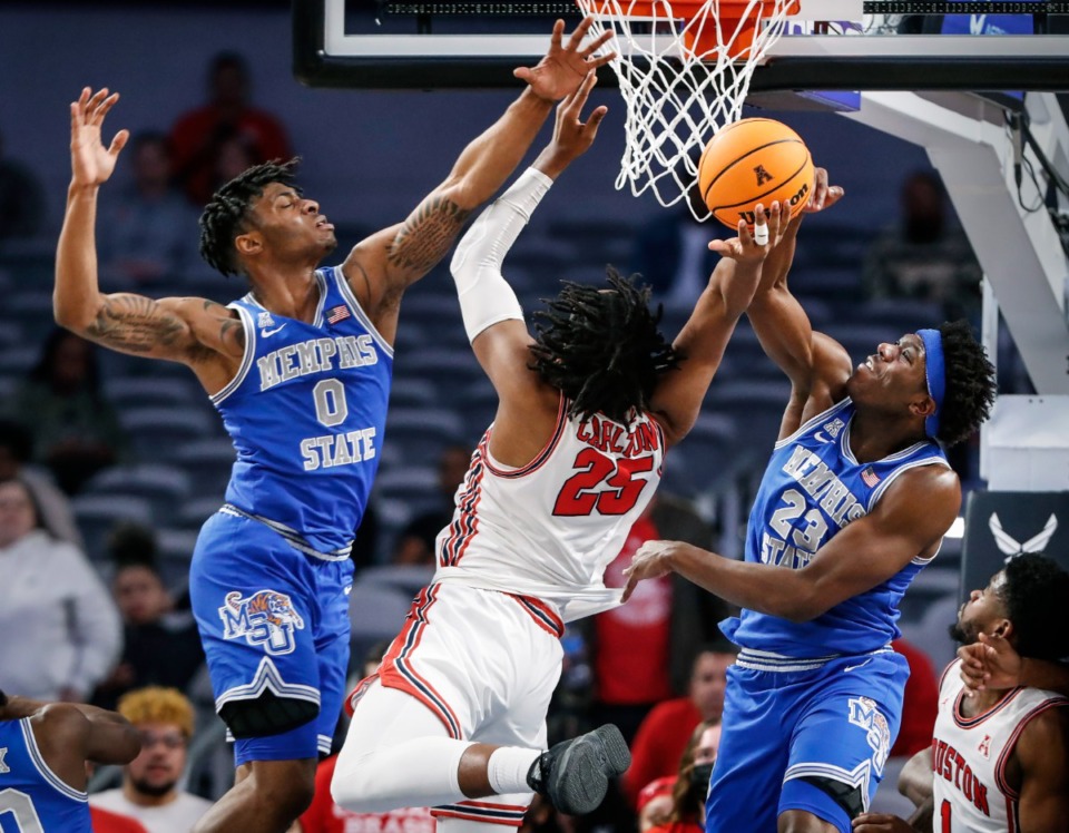 <strong>Houston forward Josh Carlton (middle) is fouled by Tigers defenders Earl Timberlake (left) and Malcolm Dandridge (right) during action on Sunday, March 13, 2022 in the AAC Championship game in Fort Worth, Texas.</strong> (Mark Weber/The Daily Memphian)