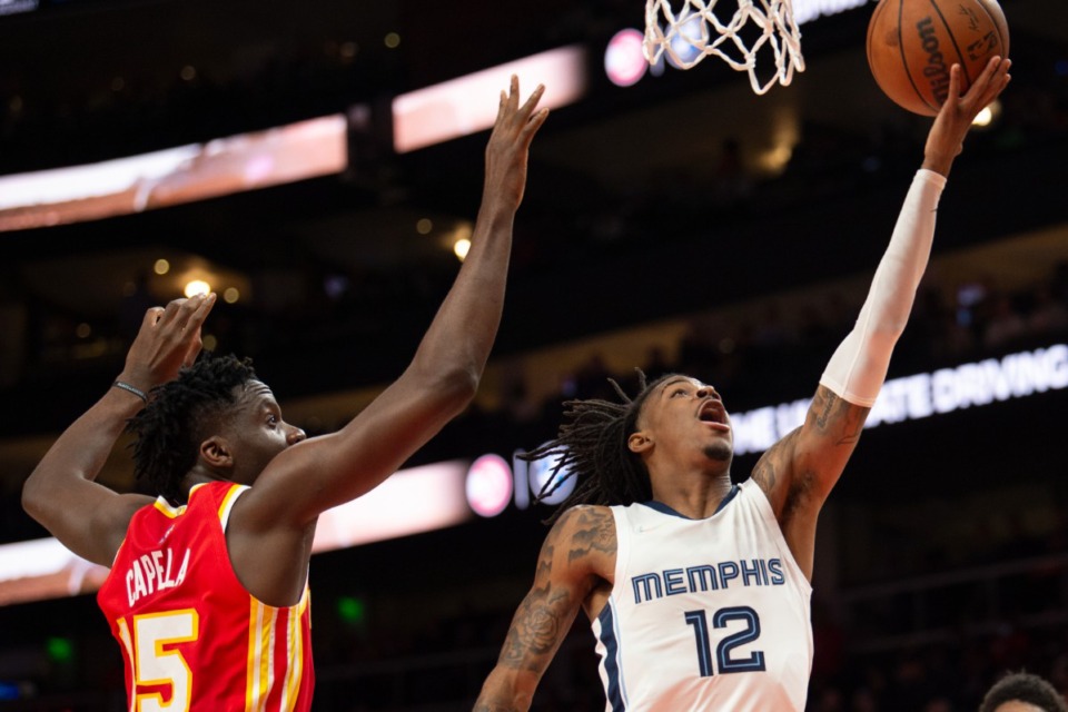 <strong>Memphis Grizzlies guard Ja Morant (12) scores past Atlanta Hawks center Clint Capela (15) on March 18, 2022, in Atlanta.</strong> (Hakim Wright Sr./AP)