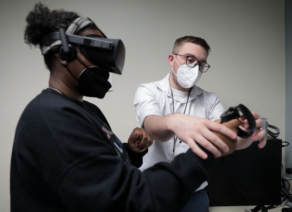 <strong>Dr. Patrick Fiddler helps Arielle Earthman, a patient&nbsp;with a traumatic brain injury (TBI), put on VR goggles at Southern College of Optometry. There were&nbsp;60,611 traumatic brain injury-related deaths in 2019, according to the Centers for Disease Control and Prevention. </strong>(Patrick Lantrip/Daily Memphian)