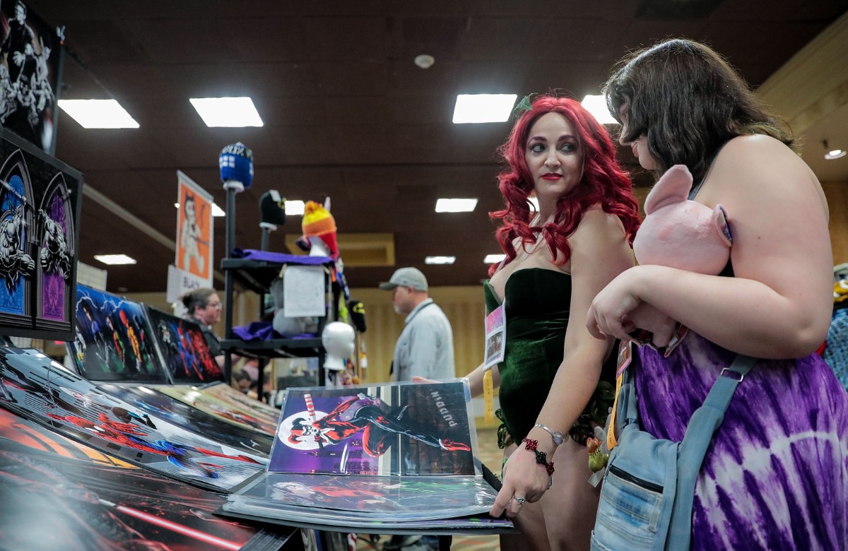 <strong>Marissa Kuder, dressed as Poison Ivy, and her daughter Kaolin Kuder shop for pictures at MidSouthCon.</strong> (Patrick Lantrip/Daily Memphian)