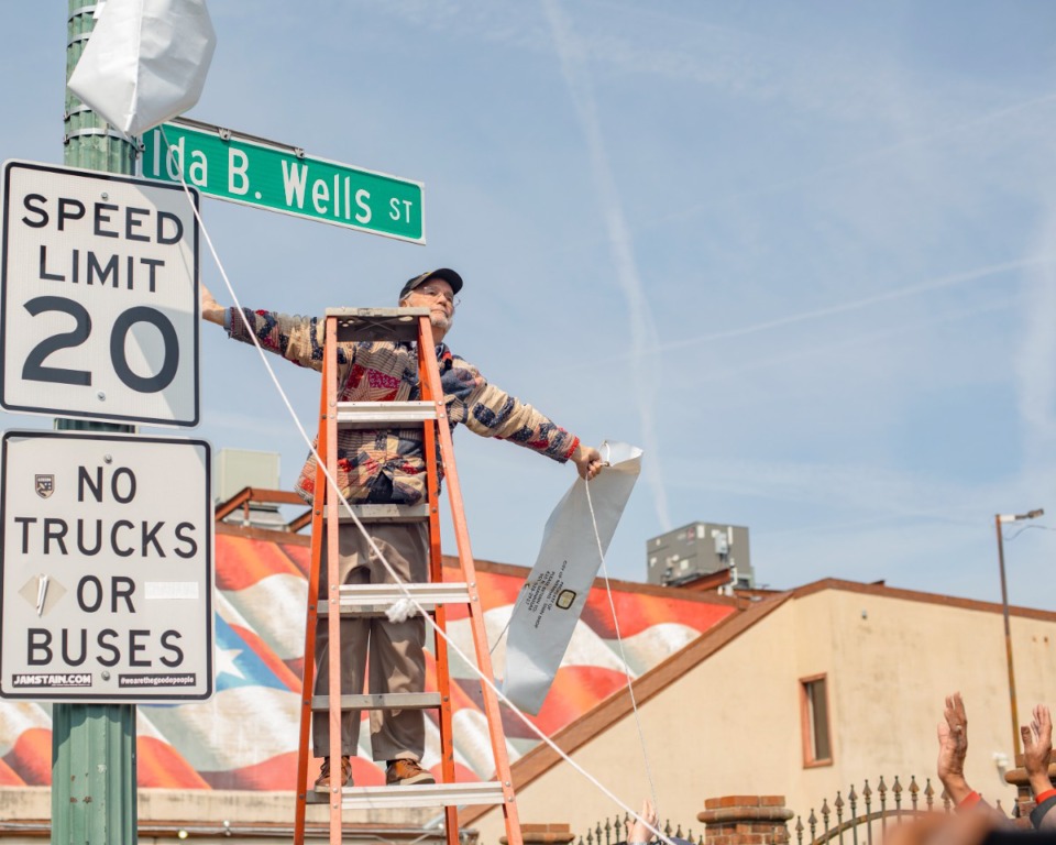 <strong>Historian Jimmy Ogle unveils the new Ida B. Wells Street sign at the corner of Fourth and Beale.</strong> (Houston Cofield/Special To The Daily Memphian)
