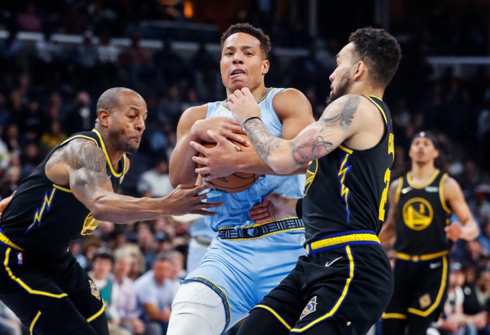 <strong>Memphis Grizzlies guard Desmond Bane (middle) is fouled while driving the lane against Golden State Warriors defenders Andre Iguodala (left) and Chris Chiozza (right) on March 28, 2022, at FedExForum.</strong> (Mark Weber/The Daily Memphian)