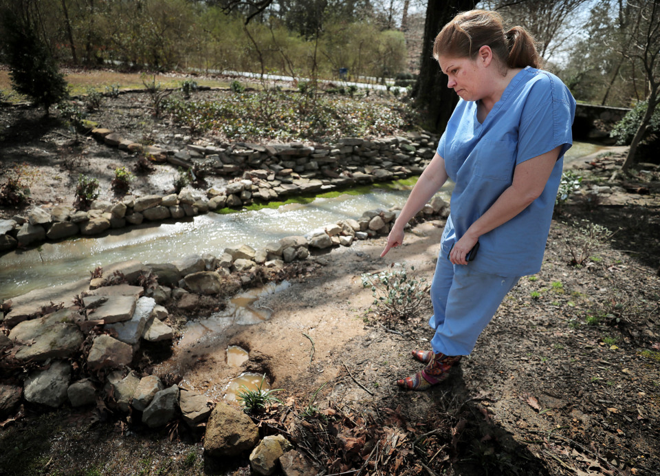 <strong>Jody LaFleur, who lives on Bridge Forest Drive just off Forest Hill Irene in Germantown, points out the high water mark near her home after heavy rain on March 13, 2019, turned her front yard into a river.&nbsp;</strong>&nbsp;(Jim Weber/Daily Memphian)