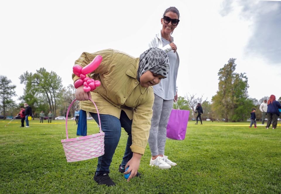 <strong>Wendy Pagenkoph (right) helps Dena Abawaji find a beeping Easter egg made by the Shelby County Sheriff&rsquo;s Office bomb squad to help visually impaired children and adults participate in an Easter egg hunt at Overton Park on Friday, April 15.</strong> (Patrick Lantrip/Daily Memphian)
