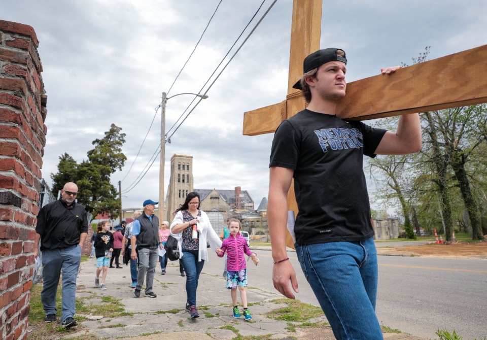<strong>Andrew Macy carries a wooden cross through the streets during St. Patrick's Catholic Church Good Friday Stations of the Cross procession.</strong> (Patrick Lantrip/Daily Memphian)