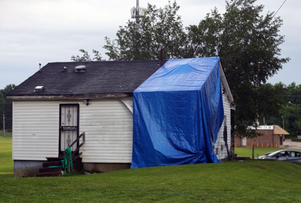 <strong>A tarp covers the hole left by a car that stuck and killed Galen Young while he was sitting in the living room of his mother's house on June 5, 2021.</strong> (Patrick Lantrip/Daily Memphian file)