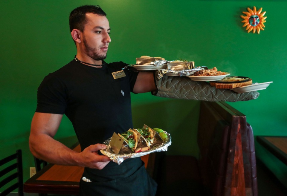 <strong>Martin Alvarez, one of the partners&nbsp; at Ricos Tacos &amp; 'Ritas in Arlington, balances plates on the way to a table.</strong> (Patrick Lantrip/Daily Memphian)