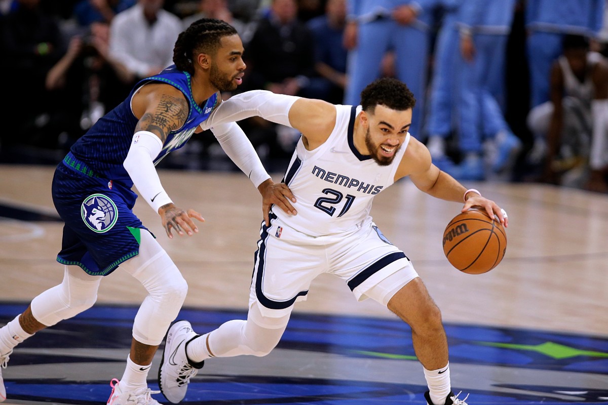 <strong>Grizzlies guard Tyus Jones (21) drives on Minnesota Timberwolves guard D'Angelo Russell (0) on April 21, 2022, in Minneapolis.</strong> (Andy Clayton-King/AP)