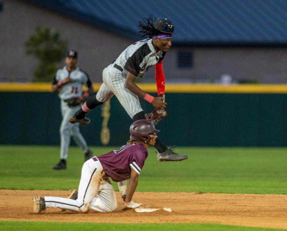 <strong>Collierville centerfielder Austin Smith clings to the base as Houston High School's Ryan Mitchell leaps to make a play at second during the third inning at Collierville High School on Tuesday, April 26, 2022.</strong> (Greg Campbell/Special to The Daily Memphian).