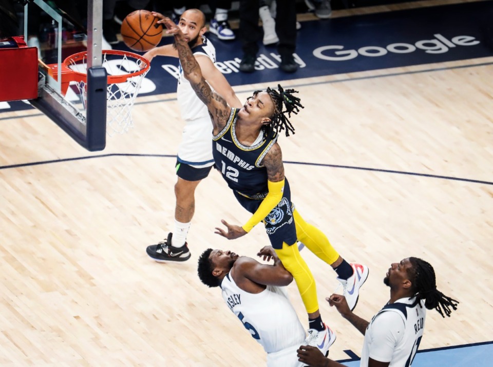 <strong>Memphis Grizzlies guard Ja Morant (top) dunks over Minnesota&rsquo;s Malik Beasley (left) and Naz Reid (right) on Tuesday, April 26, 2022, at FedExForum.</strong> (Mark Weber/The Daily Memphian)