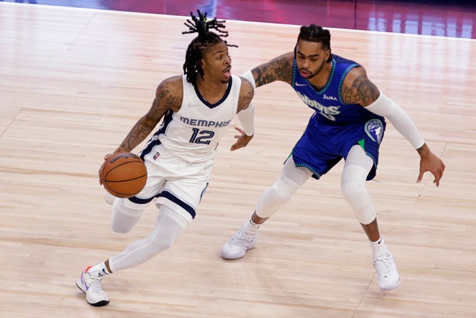 <strong>Memphis Grizzlies guard Ja Morant (12) drives around Minnesota Timberwolves guard D'Angelo Russell (0) in Game 6 of the first-round playoff series Friday, April 29, 2022, in Minneapolis.</strong> (Andy Clayton-King/AP)