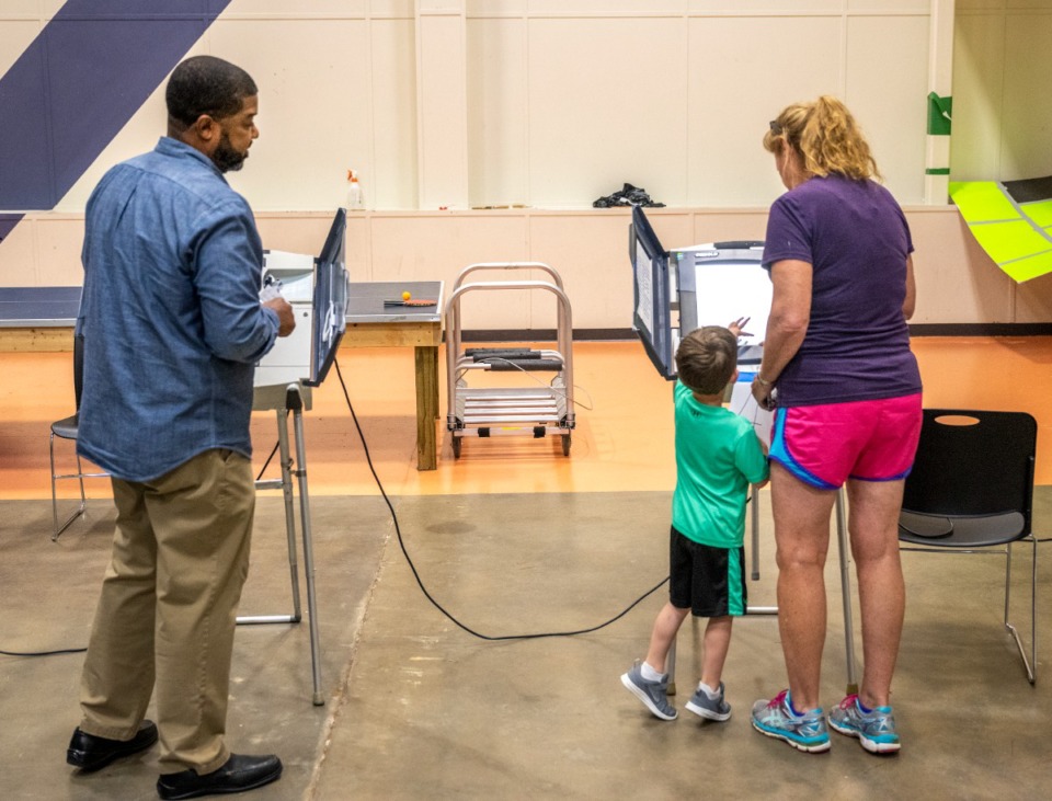 <strong>Poll worker Chris Evans, left, watches as Cheryl Bragdon votes with the help of her grandson, Dominic Pitcock, 4, at Hope Church on Tuesday, May 3, 2022.</strong> (Greg Campbell/Special to The Daily Memphian)