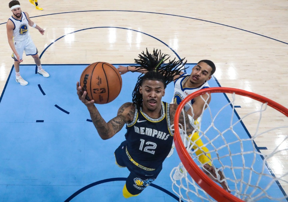 <strong>Golden State Warriors stand flat-footed as Memphis Grizzlies guard Ja Morant (12) finishes at the rim Tuesday night.</strong> (Patrick Lantrip/Daily Memphian)