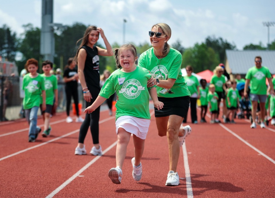 <strong>Meg Payne helps Collierville Elementary student Swayze Cupp run during the annual Dragon&nbsp;Games, a K-12 field day for students with special needs in the Collierville Schools system. The event was held at Collierville High School on Thursday, May 5.</strong> (Patrick Lantrip/Daily Memphian)