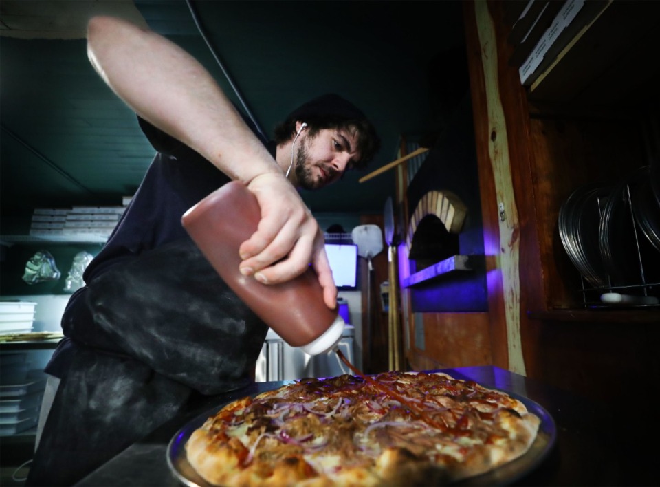 <strong>Taylor "Ninja" Sachenbacher prepares a barbeque pizza in the restaurant at the Barrettville General Store in 2021.</strong> (Patrick Lantrip/Daily Memphian)