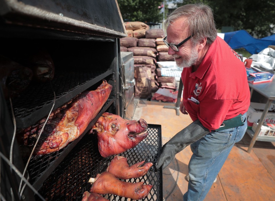 <strong>Bill Scudder with Crosstown Cookers, one of the earliest barbecue teams still in competition, checks on his whole hog during the first day of the 2019 Memphis in May World Championship Barbecue Cooking Contest at Tom Lee Park on May 15, 2019.</strong> (Jim Weber/Daily Memphian)
