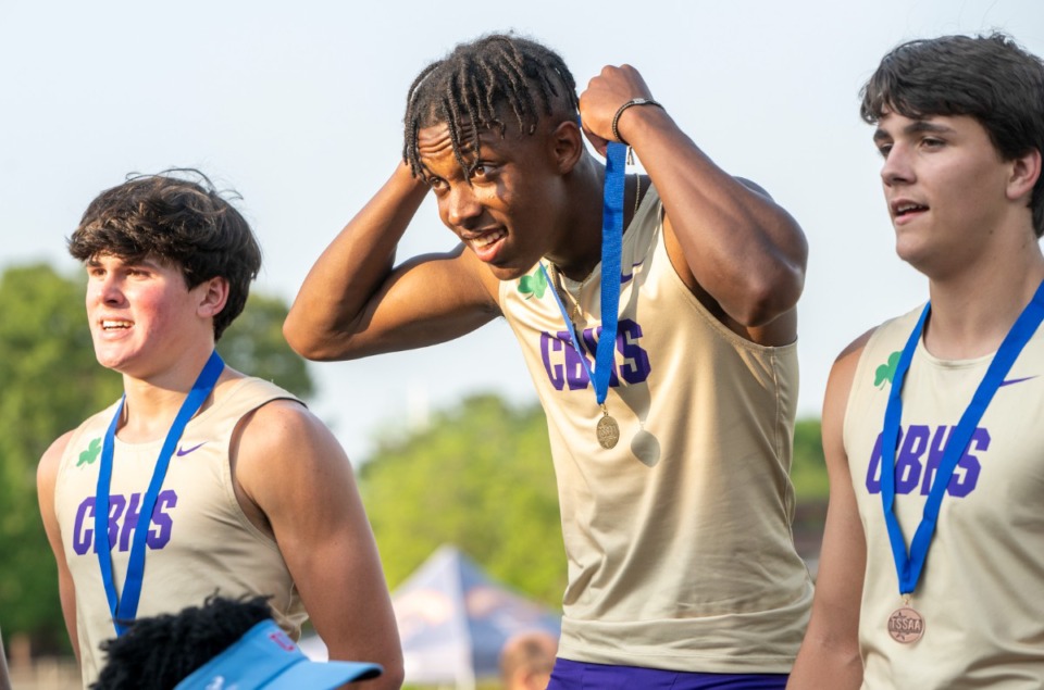 <strong>Jaxon Hammond of CBHS puts on his first-place medal after winning the men's 100-meter dash with a time of 10.52 for a personal best at the regional meet at MUS on Thursday, May 12, 2022.</strong> <strong>Teammates Whit Collard and Charlie Harrell join Hammond on the winners stand.</strong> (Greg Campbell/Special to The Daily Memphian)