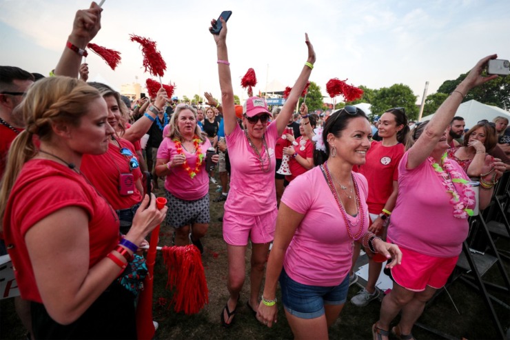 <strong>Cheryl Benson (center) and Sarah Williams (left) walk on stage to accept the award for best shirt on behalf of the I Only Smoke When I Drink tent during the second day of the Memphis in May World Championship Barbecue Cooking Contest on May 12, 2022.</strong> (Patrick Lantrip/Daily Memphian)