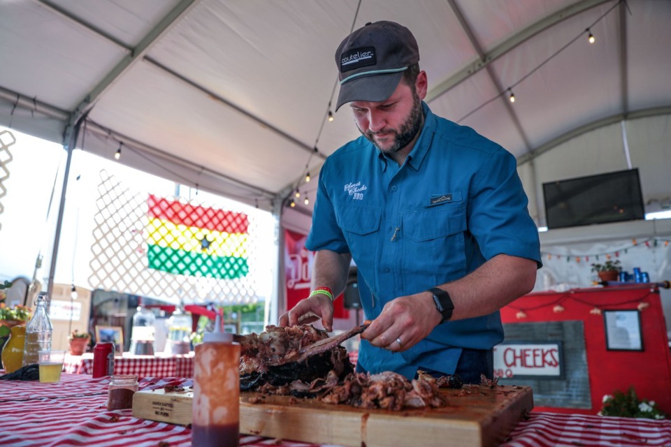 <strong>John Jordan Proctor with the Sweet Cheeks BBQ tent carves up a pork shoulder during the last day of the competition at Liberty Park. His team won third place in the shoulder division.&nbsp;</strong>(Patrick Lantrip/Daily Memphian)