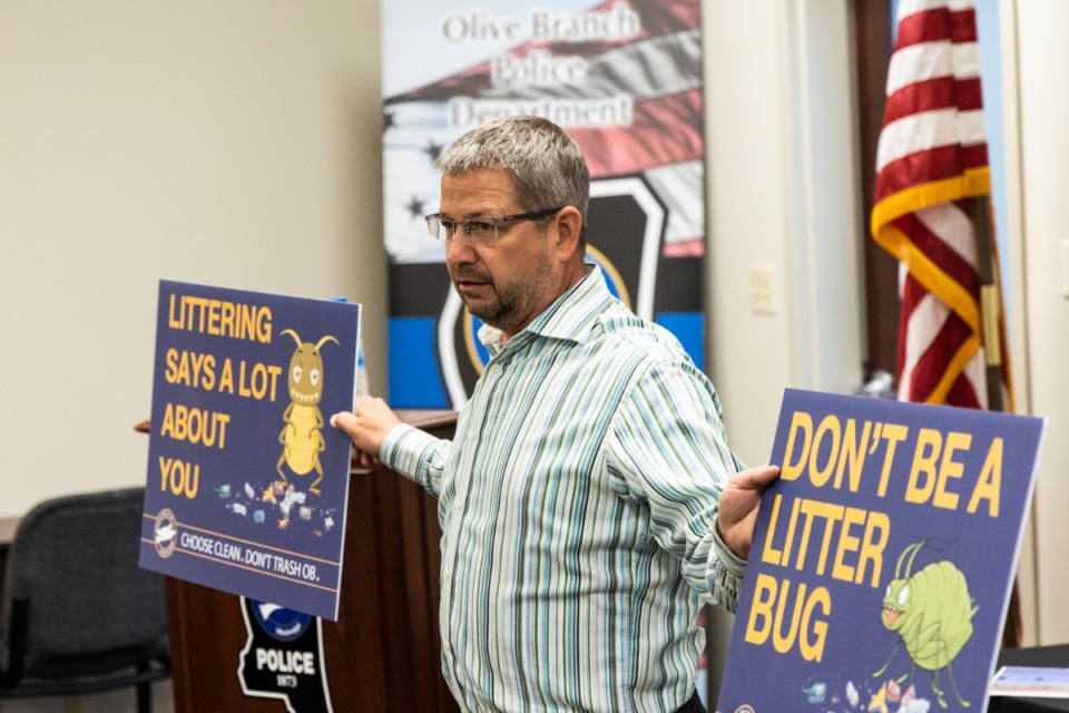 <strong>Jay Nichols, communications manager for the city of Olive Branch, shows off anti-littering signs during an Olive Branch Beautification Committee meeting.</strong> (Brad Vest/Special to The Daily Memphian)