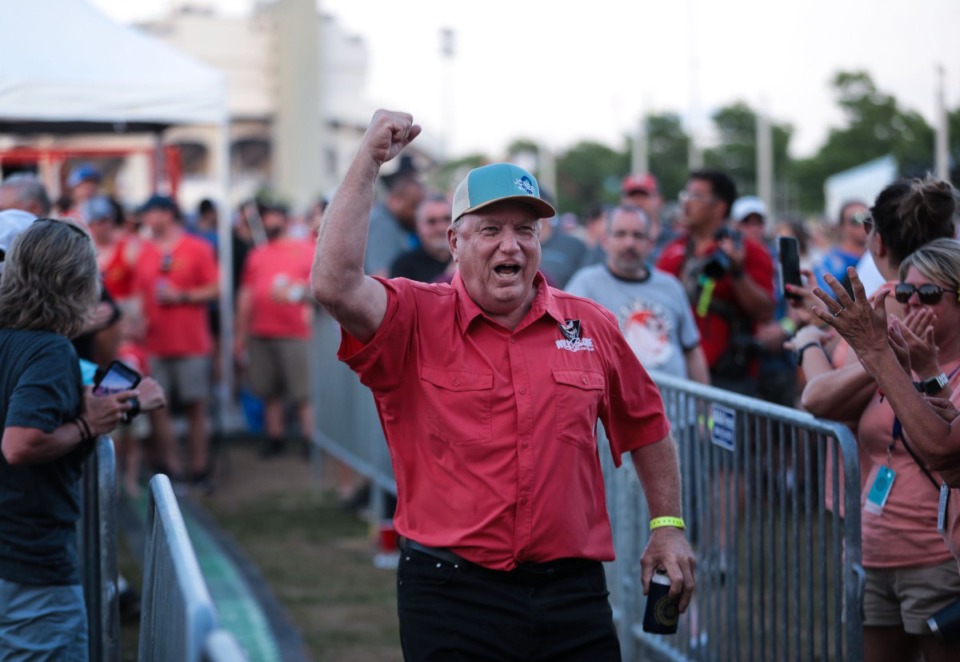 <strong>A member of the Will-B-Cue Team runs up to the stage to accept the third-place trophy in the whole hog category during the last day of the Memphis in May 2022 World Championship Barbecue Cooking Contest.</strong> (Patrick Lantrip/Daily Memphian)