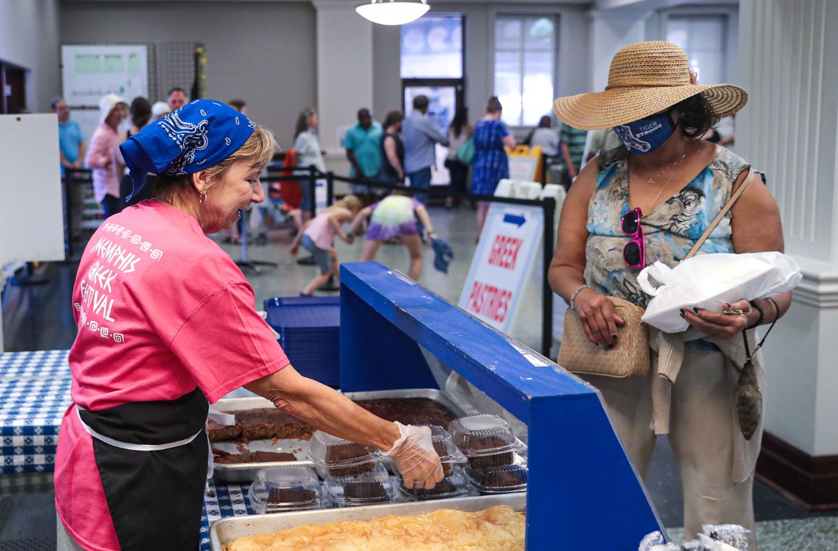 <strong>Beverly Vieron (left) passes out traditional Greek pastries at Memphis Greek Festival on May 20, 2022.</strong> (Patrick Lantrip/Daily Memphian)