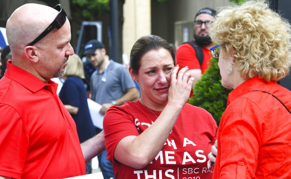 <strong>Sexual abuse victim Jules Woodson, center, of Colorado Springs, Colorado., is comforted by her boyfriend Ben Smith, left, and Christa Brown while demonstrating outside the Southern Baptist Convention&rsquo;s annual meeting Tuesday, June 11, 2019, in Birmingham, Alabama. The For Such A Time As This protest calls for a change in the way the SBC views and treats women and demands action to combat sexual abuse within the establishment.</strong> (AP File Photo/Julie Bennett)